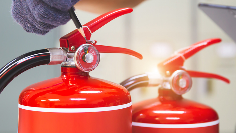 Fire extinguisher has hand engineer inspection checking pressure gauges to prepare fire equipment for protection and prevent in emergency case and safety or rescue and alarm system training concept.